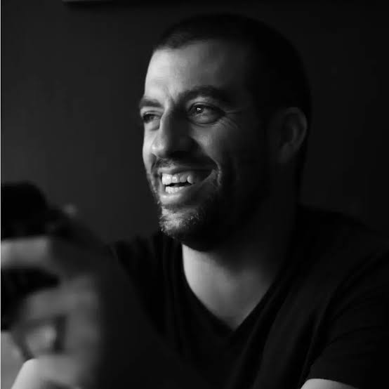 Nate Strubhar of Sunlit Films, laughing behind a camera